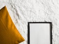 Black thin wooden frame with blank copyspace as poster photo print mockup, golden cushion pillow and fluffy white Royalty Free Stock Photo