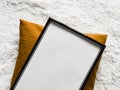 Black thin wooden frame with blank copyspace as poster photo print mockup, golden cushion pillow and fluffy white Royalty Free Stock Photo