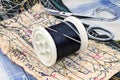 Black thread with a needle on a plastic spool and scissors on the work table of a tailor Royalty Free Stock Photo