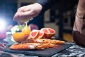 Black Tiger Shrimps. Chef hand squeezing lemon juice dribbling out of fruit. Roasted prawns with herbs. Grilled seafood Royalty Free Stock Photo