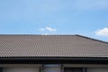 Black tile roof of construction townhouse with blue sky and cloud background.