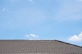 Black tile roof of construction townhouse with blue sky and cloud background.