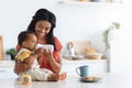 Black Toddler Boy Drinking Water From Bottle With Smiling Mom In Kitchen Royalty Free Stock Photo