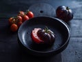 Black tomato sliced on a black plate