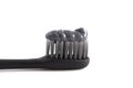 A Black Toothbrush with Black Activated Charcoal Toothpaste on a White Background Royalty Free Stock Photo