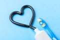 Black toothpaste from charcoal for white teeth. Tooth-paste in the form of heart, tube and toothbrush on blue Royalty Free Stock Photo