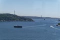 Black touristic ferry traveling Bosphorus front of the bridge