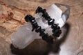 Black Tourmaline Bracelet wrapped around Lemurian rainbow quartz point from Brazil on Natural Polished Petrified wood slab