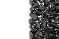 Black tourmaline heap jewel on half light surface texture. Pile mineral pebbles background.