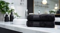 Black towels on marble desk in the foreground and blurred modern bathroom Royalty Free Stock Photo