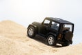 Black toy car on the desert
