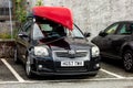 Black Toyota Avensis estate car with a red kayak at the roof for a river adventure which is limiting the view for a driver