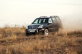 Black Toyota Prado SUV rides in the field in the rays of the sunset