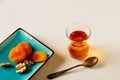 Black traditional Turkish tea in a glass cup and dried fruits on a white table. Royalty Free Stock Photo