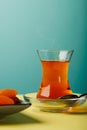 Black traditional Turkish tea in a glass cup and dried fruits on a white table. Royalty Free Stock Photo