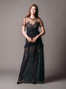 Black transparent long evening dress. Beautiful slim bending model, modern feminine look for a party.