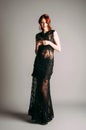 Black transparent long evening dress. Beautiful slim bending model, modern feminine look for a party.