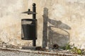 Black trash can near the wall. Royalty Free Stock Photo