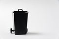 Black trash can on white background. Garbage tank. Copy space