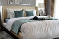 Black tray of tea set with white and green pillows on bed