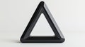 A black triangular prism with a cutout in the center. Royalty Free Stock Photo