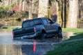 A black truck driving through flooded park