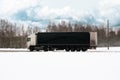 Black truck driving on the winter road in rural landscape Royalty Free Stock Photo