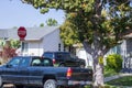 Black truck parked by a house with a red stop sign in front of it in Northridge, California Royalty Free Stock Photo