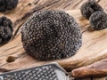Black truffle mushrooms and grater on wooden background. Close-up