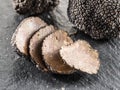 Black truffles and truffle slices on the graphite board Royalty Free Stock Photo