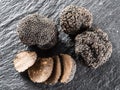 Black truffles and truffle slices on a graphite board. Royalty Free Stock Photo