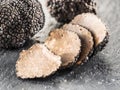 Black truffles and truffle slices on the graphite. Royalty Free Stock Photo