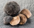 Black truffles and truffle slices on a graphite board. Royalty Free Stock Photo