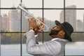 Black trumpeter performing at daytime.