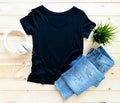 Black tshirt mockup and short jeans on brown wooden background. Template, flat lay, template