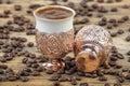 Black Turkish coffee in copper cup and roasted coffee beans scattered on wooden table. Traditional Turkish coffee in copper cup Royalty Free Stock Photo