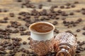 Black Turkish coffee in copper cup and roasted coffee beans scattered on wooden table. Traditional Turkish coffee in copper cup Royalty Free Stock Photo