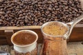 Black Turkish coffee in copper cup and roasted coffee beans scattered on wooden table. Traditional Turkish coffee in copper cup Royalty Free Stock Photo