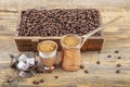 Black Turkish coffee in copper cup and roasted coffee beans scattered on wooden table. Traditional Turkish coffee in copper cup Royalty Free Stock Photo