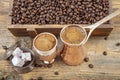 Black Turkish coffee in copper cup and roasted coffee beans scattered on wooden table. Traditional Turkish coffee in copper cup Royalty Free Stock Photo