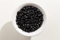 Black Turtle Bean legume. Top view of grains in a bowl. White ba