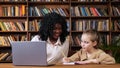 Black tutor and schoolgirl give each other five at table