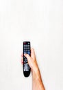 Black TV remote control in mens hand on a light gray background Royalty Free Stock Photo