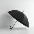 A black umbrella leans against a plain white wall. Its curved handle rests on the floor Royalty Free Stock Photo