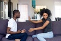 African unhappy married couple sitting on couch quarrelling at home