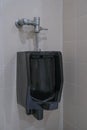 Black urinal of men with tile wall