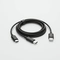 A black USB cable is coiled neatly against a light grey background. One end features a Royalty Free Stock Photo