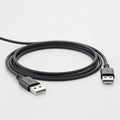 Black USB cable with standard Type-A connectors at both ends. The cable is coiled Royalty Free Stock Photo