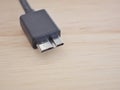 Black USB cable with usb3 connector on board wood with high-speed data transfer concept