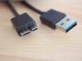 Black USB cable with usb3 connector on board wood with high-speed data transfer concept